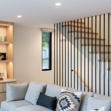 North Vancouver Modern Staircase Renovation North Vancouver Staircase Renovation with framed vertical wood slats, creating a stylish visual partition from the family room.