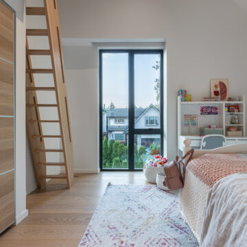 North Vancouver Home Renovation Kid's Room with Large Window and Minimalist Design Charming children's bedroom featuring a loft-access ladder, light wood flooring, cozy bedding, playful decor, built-in shelving, and a tall black-framed window bringing in natural light and views of the neighborhood.