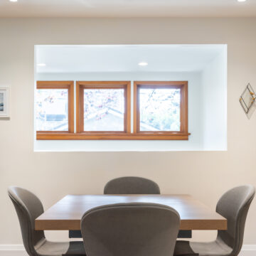 Bright dining nook featuring a wood dining table, upholstered chairs, and a recessed window opening that brings natural light into the space.